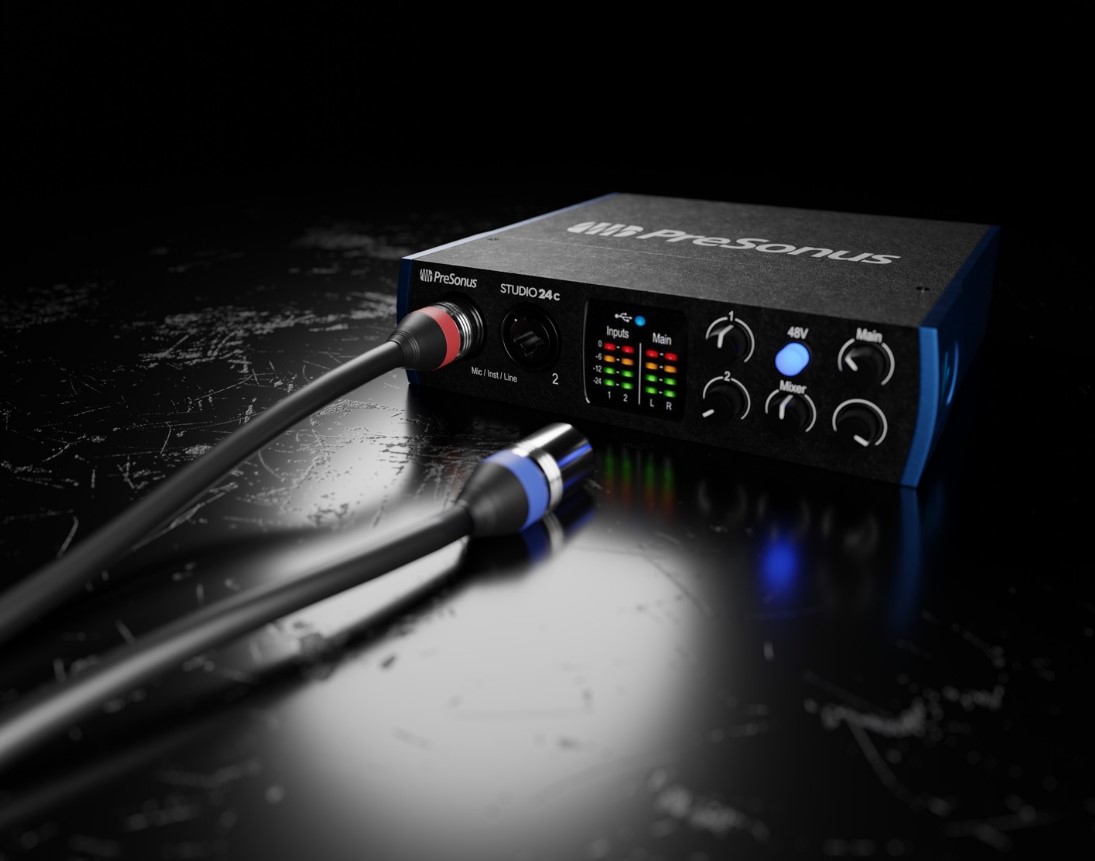 Ein PreSonus Studio 24c Audio-Interface mit Reglern, Anzeigen und angeschlossenen Kabeln.